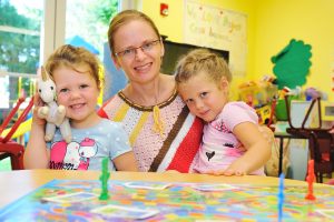 Anna and her two daughters playing a board game